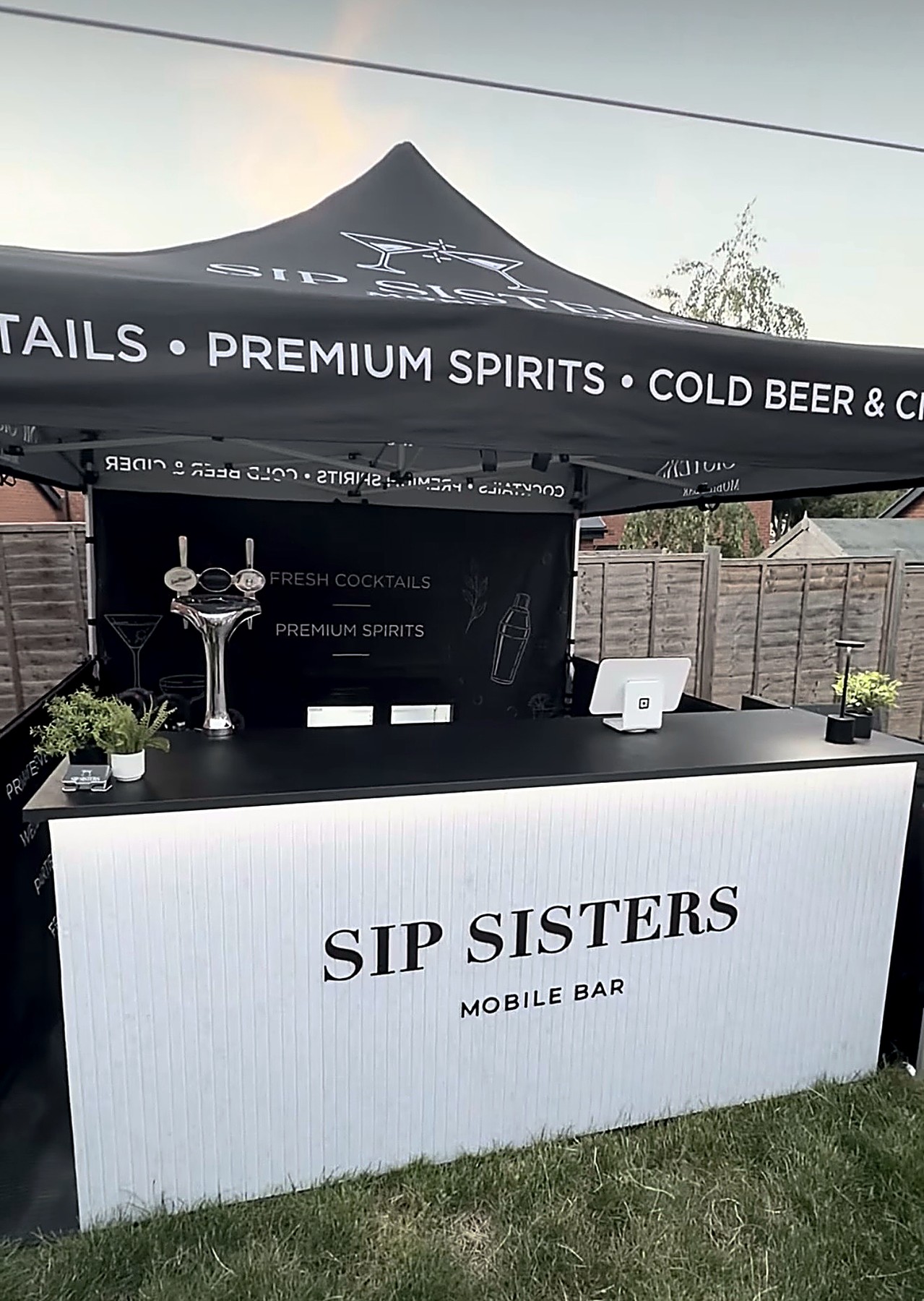 Sip Sisters pop-up bar set up outdoors under its branded gazebo