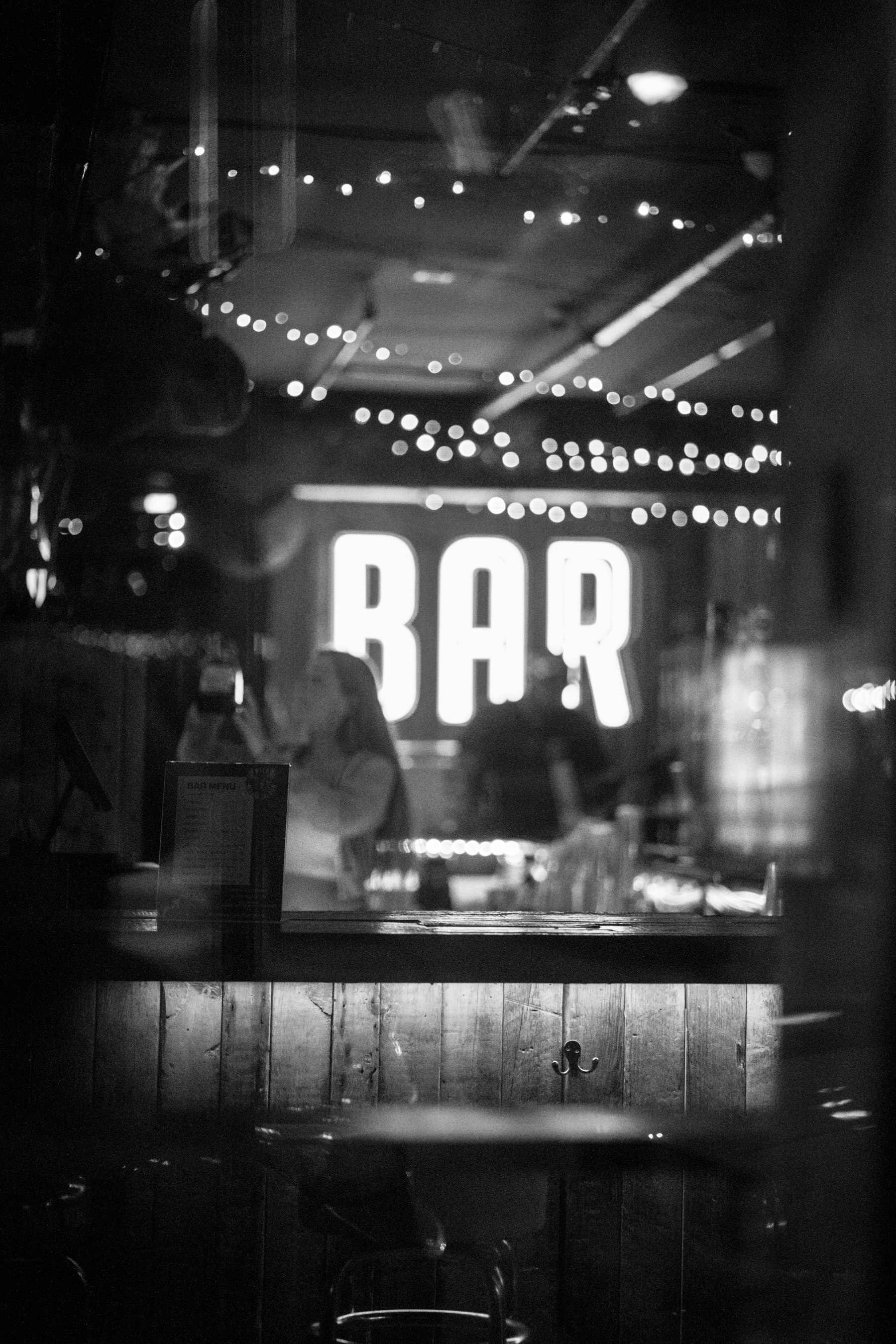 Moody black and white bar with illuminated BAR sign